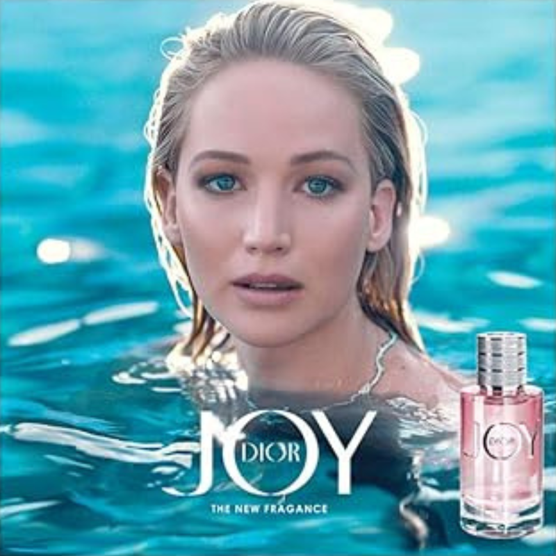 Woman in water with Dior Joy perfume bottle
