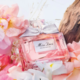 Miss Dior perfume bottle with flowers and wood log in the background