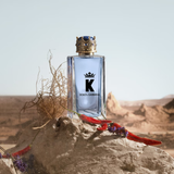 Dolce & Gabbana K perfume bottle on a desert background