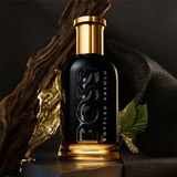 BOSS Bottled Absolu perfume bottle with gold cap and black body on a dark background
