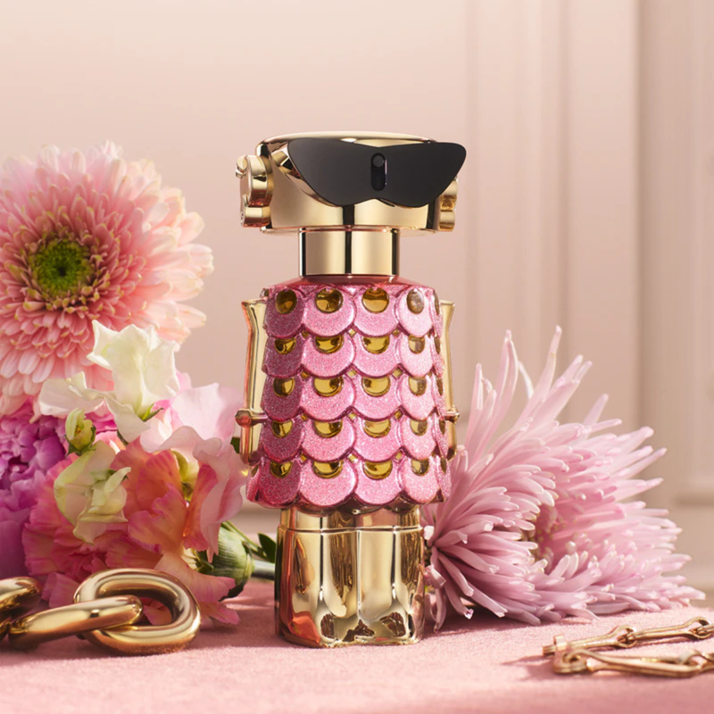 Pink and gold perfume bottle with flowers on a pink background